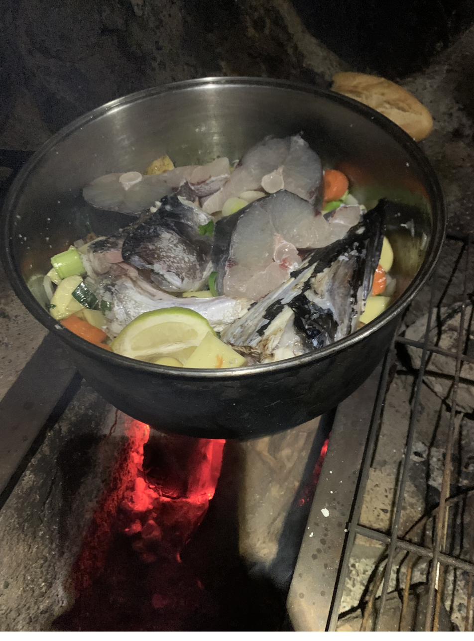 Fish stew over fire coals